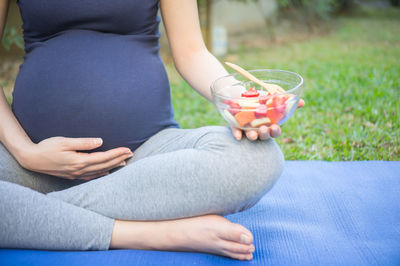 Low section of woman holding drink