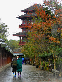 Rear view of people walking on building