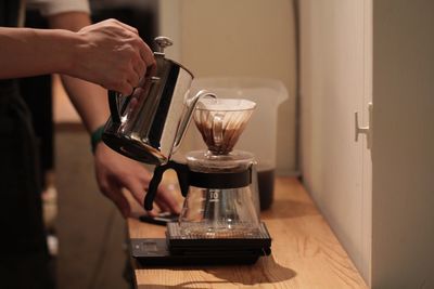 Close-up of hand pouring wine in glass