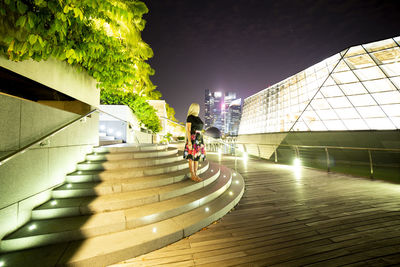 People on staircase in city against sky