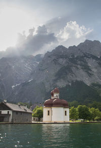 Building by mountains against sky