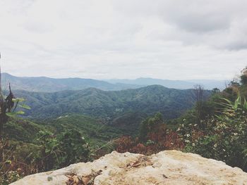 Scenic view of mountains against cloudy sky