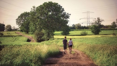 Rear view of men walking on footpath
