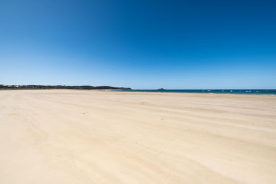 Scenic view of beach against clear blue sky