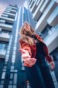 Low angle view of woman standing against building