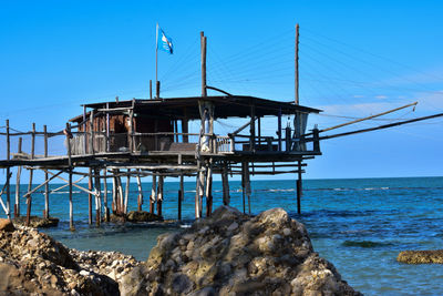 Lifeguard hut on beach against clear blue sky