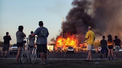 Rear view of people standing against fire