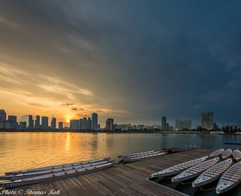 Modern buildings in city against sky during sunset