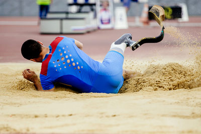 Side view of boy playing on sand at beach