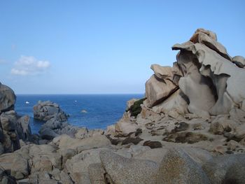 Rocks on beach against clear sky