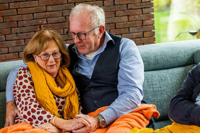 Portrait of smiling friends sitting on sofa at home