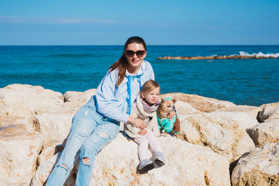 Portrait of happy friends on shore against sea