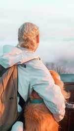 Rear view of women on shore against sky