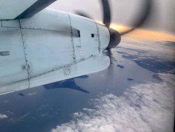 Airplane flying over sea against sky