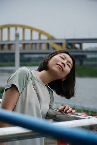 Young woman sitting on railing