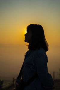Silhouette woman against sky during sunset