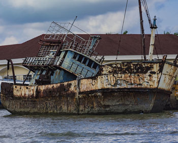 Abandoned ship on sea against sky