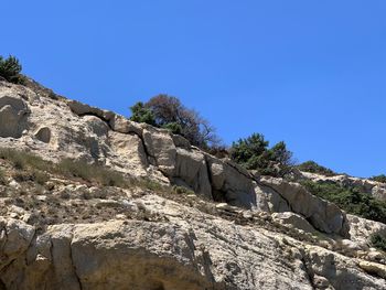 Low angle view of rock formation against clear blue sky