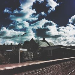 Railroad tracks against cloudy sky