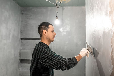 Young man standing against wall