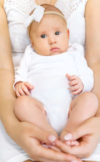 Midsection of woman with baby sitting in lap