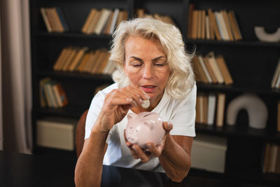 Portrait of young woman holding piggy bank