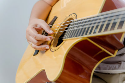 Midsection of woman playing guitar