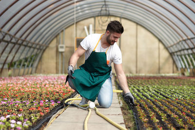 Full length of young man holding flowers