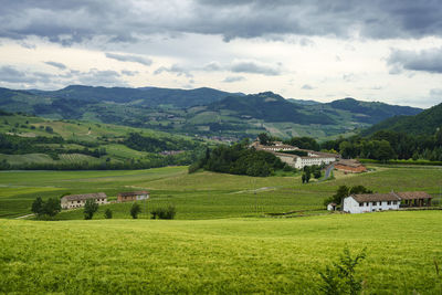 Scenic view of field and houses against sky