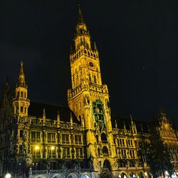 Low angle view of clock tower at night
