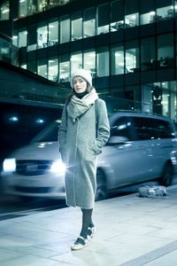 Portrait of young woman standing in car