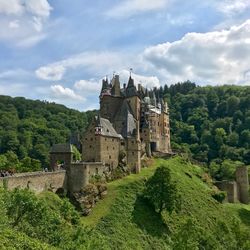 Castle by buildings against sky