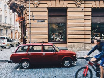 Vintage car on street against buildings in city