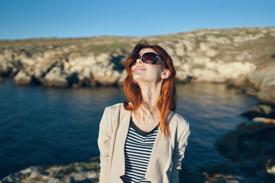 Mid adult man wearing sunglasses standing against sky