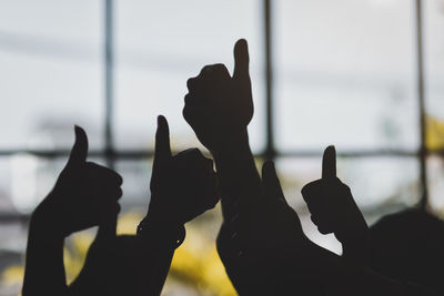 Silhouette hands gesturing thumbs up