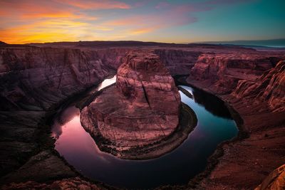 Scenic view of horseshoe bend against sky during sunset