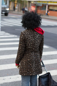 Rear view of woman crossing road