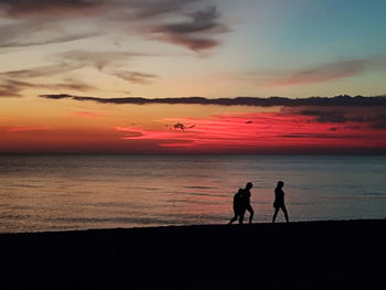 Silhouette of people on beach during sunset