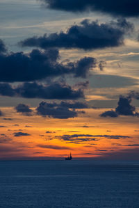 Scenic view of sea against dramatic sky during sunset