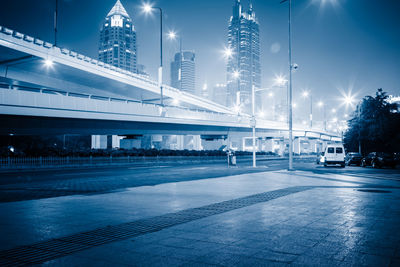 View of city street and bridge at night
