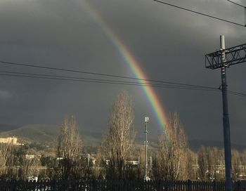 Rainbow over buildings in city against sky