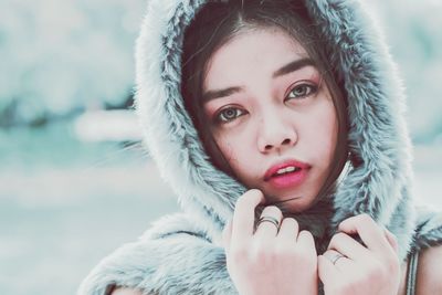 Close-up portrait of young woman wearing fur coat