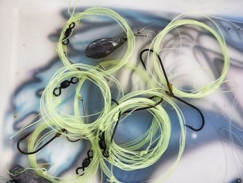 Directly above view of green strings with fishing hooks