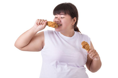 Full length of a girl eating food against white background