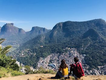 Rear view of people on mountain against sky