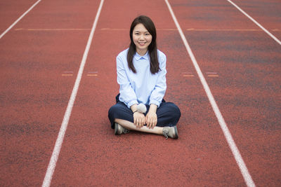 Portrait of smiling young woman sitting outdoors