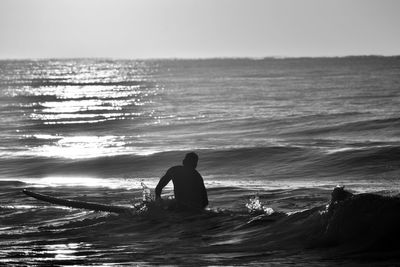 Rear view of silhouette man on beach against sky