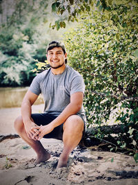 Portrait of young man sitting on land