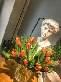 Close-up of statue by flower bouquet