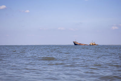 Boat sailing in sea against sky